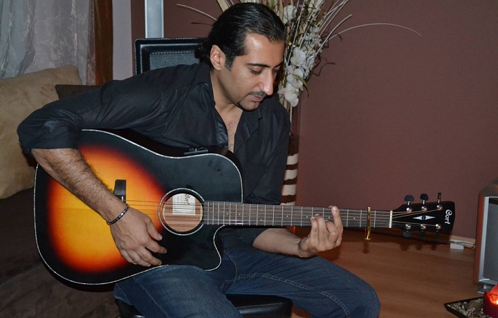 Ali Amiri hraje na kytaru. 