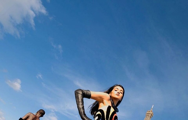 Žena v barevných šatech Balmain pod Eiffelovou věží