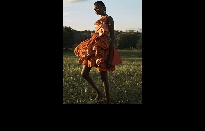 Žena v oranžových mačkaných šatech