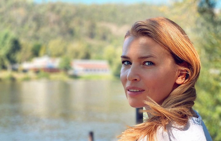 Daniela Peštová se usmívá, za ní je příroda