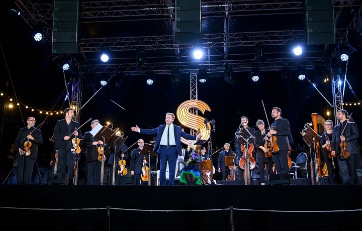 Hudebníci stojí na podiu, uprostřed houslista Daniel Hope