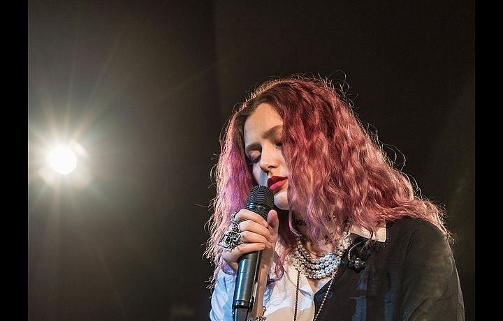 Karin Ann na jevišti s mikrofonem. 