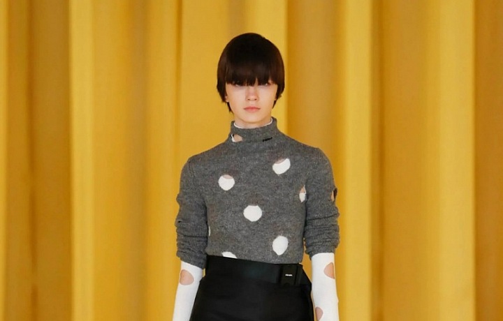 Žena v černé sukni a pleteném svetru Prada SS2021