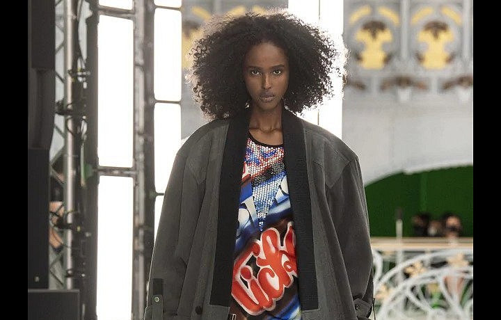 Žena v trenčkotu a barevných šatech