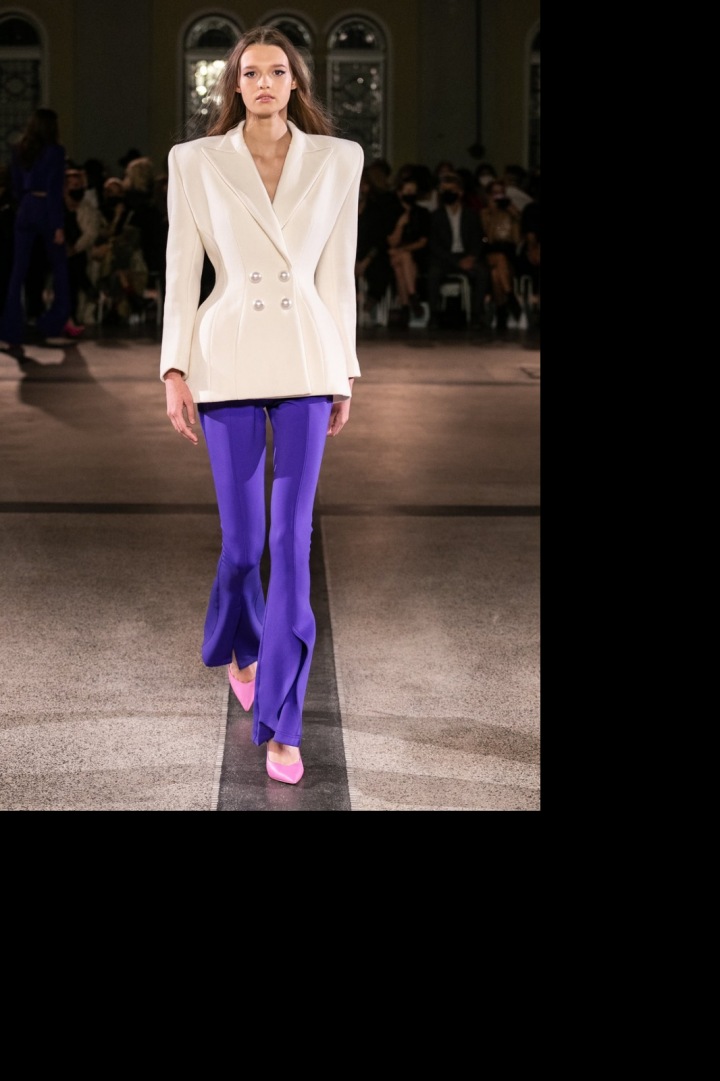 Modelka má na sobě fialovo-bílý outfit od Vandy Jandy