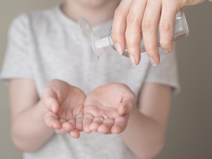 Chlapec si dává na ruce dezinfekci