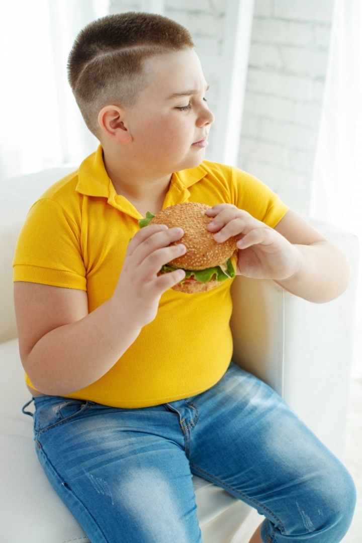 Dítě jí hamburger.