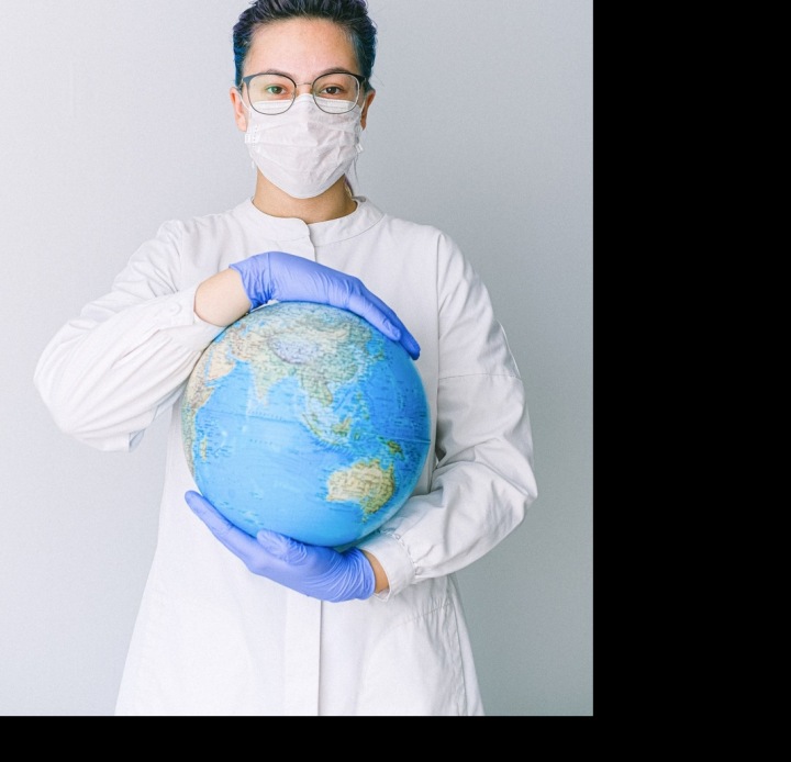 Žena v roušce s globusem