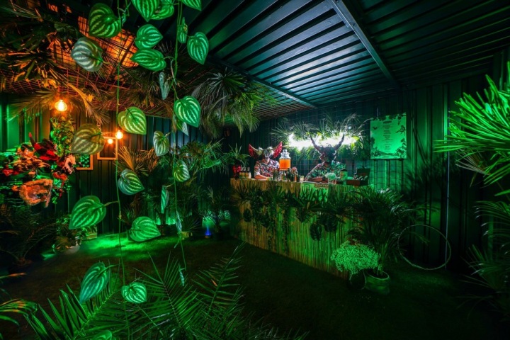 Květiny, pult a lidé v maskách