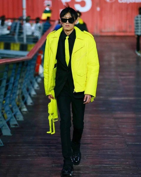 Muž v černém obleku a žluté bundě Louis Vuitton SS 2021