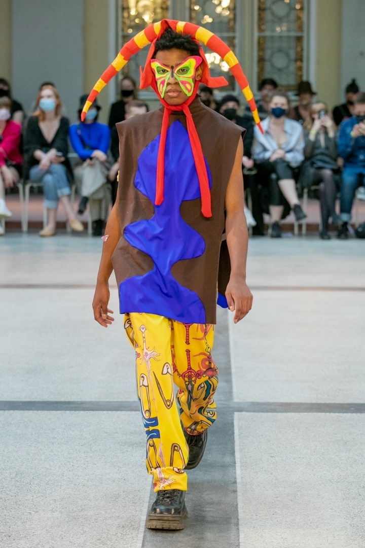 Muž ve žlutých kalhotách a modro-hnědém topu