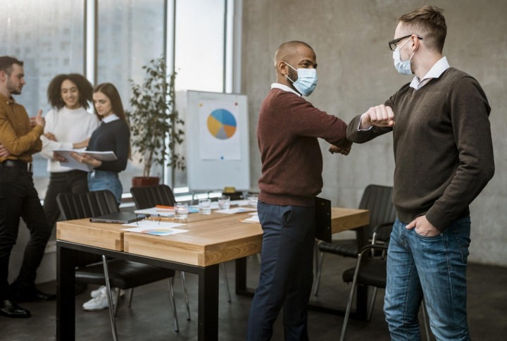 Muži v rouškách v kanceláři. 