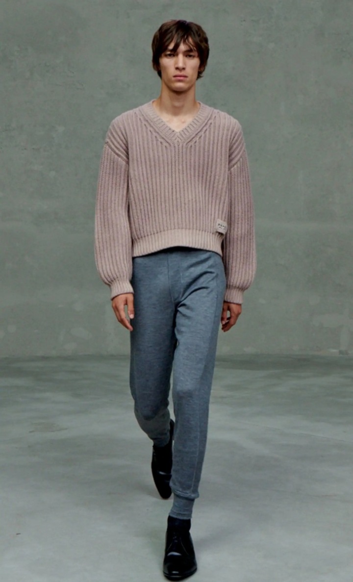 Muž v teplákách a pleteném svetru Prada