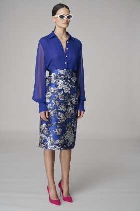 Žena v modré květované sukni a halence