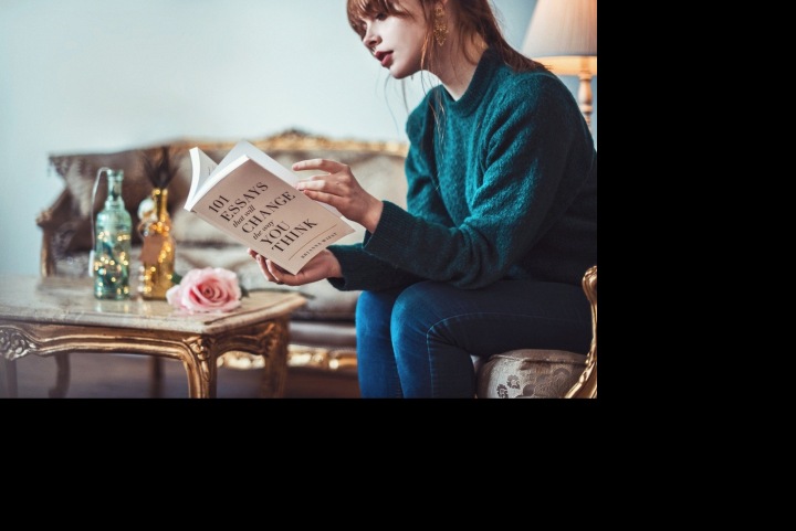 Žena u stolku a s knihou v ruce