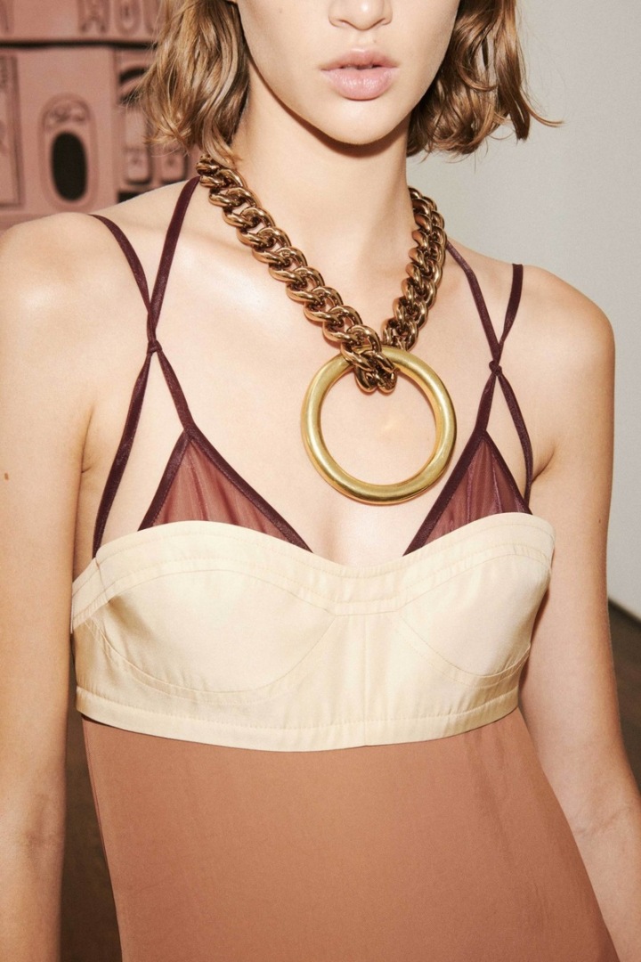 Žena v béžových šatech Victoria Beckham 