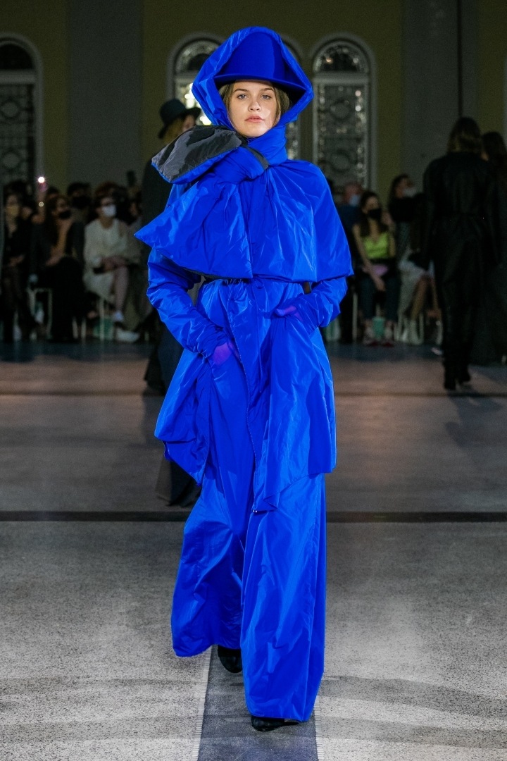 Žena v modrém outfitu s kapucí od Jakuba Polanky 
