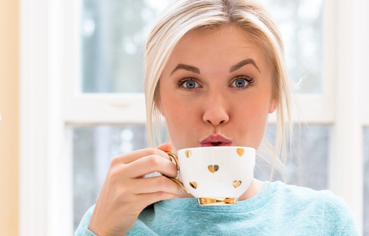 Žena pije kávu.