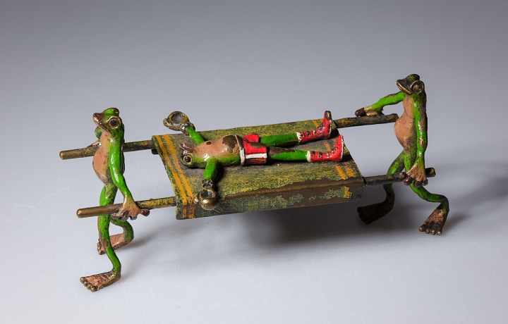 Bronzoví žabáci nesou na nosítkách opilého žabáka. 