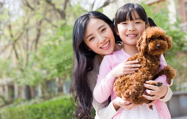 Šťastná mladá maminka s dcerou a pejskem.