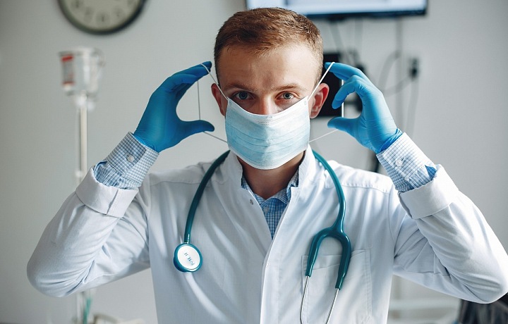 Lékař si nasazuje roušku. 