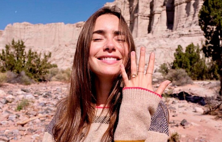 Lily Collins, na ruce zásnubní prsten s růžovým diamantem. 