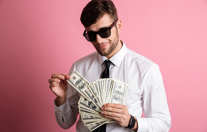 "Cool" muž ve slunečních brýlích s penězi v ruce