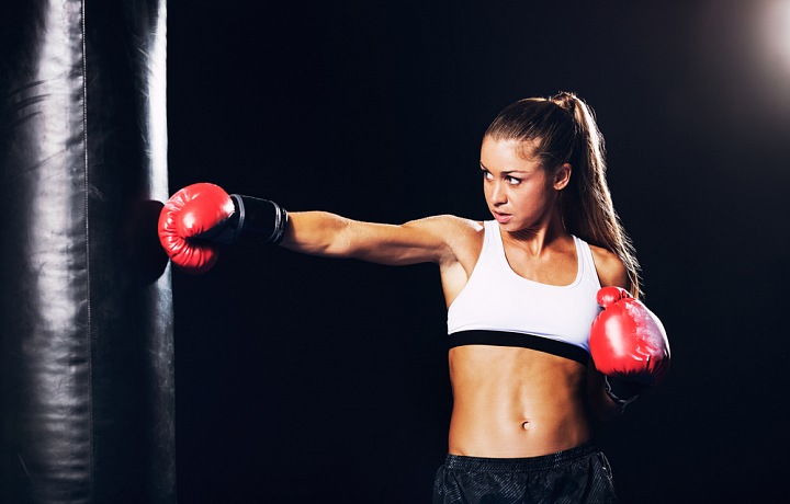 Žena sportovkyně a boxovací pytel