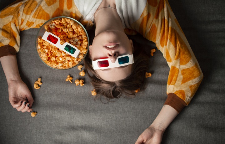Žena na gauči s popcornem