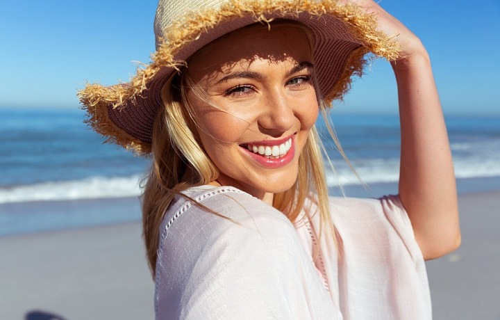 Žena ve slamáku na pláži