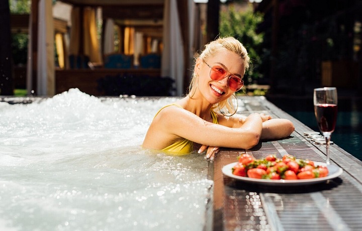 Žena ve vířivce s šampaňským. 